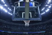 Brightly lit Basketball backboard in a large sports arena.