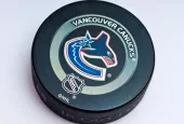 Official Vancouver Canucks game puck on the ice ^product shot