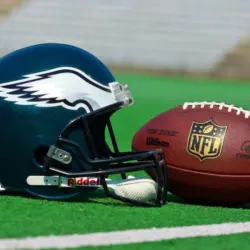 Philadelphia eagles equipment ^ ball and helmet on the green playing field ^ product shot AUGUST 13^ 2015