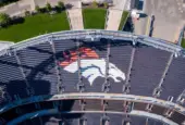 Aerial Top-Down View of Denver Broncos Logo in Empty Stadium Seats at Empower Field May 26^ 2022 Denver^ Colorado