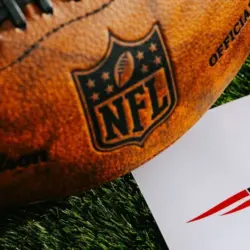 New England Patriots NFL team Logo and American football ball on Green Grass.