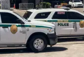 Two Miami-Dade police K-9 cars are parked near a metal security fence on a bright sunny day. Miami^ Florida^ USA^ June 16th 2025
