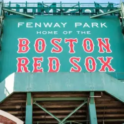 View of the historic architecture of the Fenway Park Stadium showcasing its signs^ brick walls^ statues^ and the famous green color and red letters of the red sox. Boston^ MA^ USA - March 10^ 2023