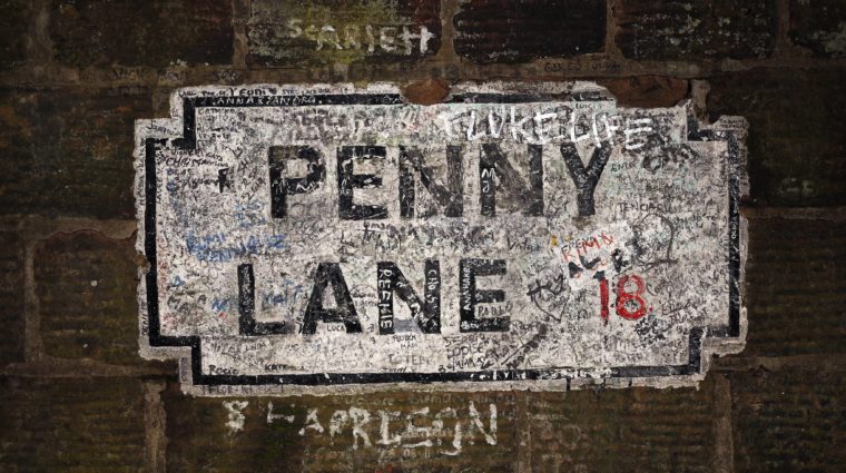 graffiti-left-by-beatles-fans-covers-a-painted-road-sign-on-a-wall-on-penny-lane-in-liverpool-northern-england