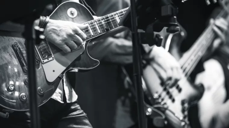 Rock and roll music background^ guitar players on a stage^ monochrome photo with selective focus