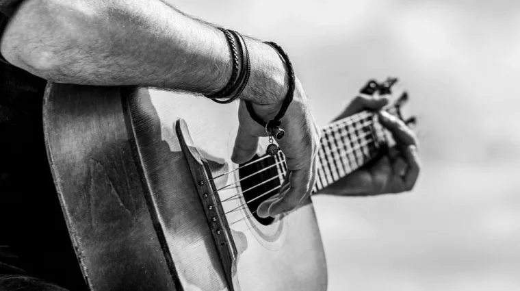 Acoustic guitars playing. Music concept. Black and white. Male musician playing guitar^ music instrument. Man's hands playing acoustic guitar^ close up.