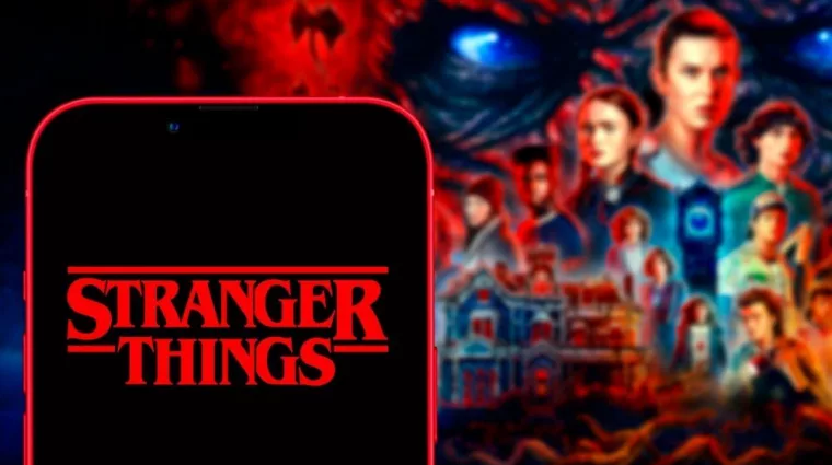 Computer keyboard with the Iphone 11 pro with the Stranger Things logo.