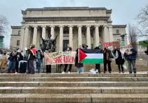 Pro-Palestinian students holding "Money Talks Strike Tuition" banner and Palestinian flag at a protest in front of Low Library on the Columbia University campus New York^ NY USA - January 19^ 2024