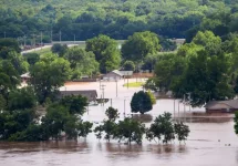 View from 412 Highway to the West of Tulsa Oklahoma as Arkansas river rises and innodates residential area with houses flooded and cars parked in water and a RV tipping over Sand Springs USA 5-25-2019