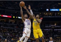 Realistic photography of two basketball players fighting in the air to catch the ball falling after a failed shot in an nba game. one basketball player is from the oklahoma city thunder and the other basketball player is from the indiana pacers. the photo
