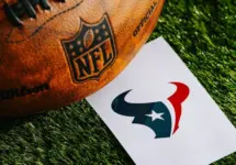 Houston Texans NFL team Logo and American football ball on Green Grass. HOUSTON^ USA^ FEBRUARY 10^ 2025
