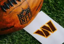 Washington Commanders NFL team Logo and American football ball on Green Grass.
