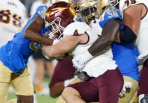 Arizona State running back Cam Skattebo #4 runs against UCLA defensive line Gary Smith III #58 and defensive back Alex Johnson #36 during an NCAA college football game^ Nov. 11^ 2023^ in Pasadena.