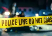 Yellow Tape Showing Text "Police Line Do Not Cross" Restricting a Crime Scene Area At Night. Close Up Aesthetic Shot with Bokeh Effect and Flickering Lights. Criminal on the Loose Strikes Again