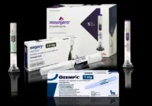 Injection pens and packaging boxes of weight-loss and type 2 diabetes medication Mounjaro^ Wegovy^ Ozempic^ Zepbound Isolated on black background with reflections.