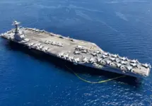 Aerial drone photo of USS Gerald R. Ford latest technology nuclear powered aircraft carrier anchored in deep blue open ocean sea