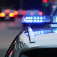 police patrol car with blue flashing light on the roof of the police car. Alarming in the evening.