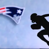 New England Patriots. Silhouette of professional american football player. Logo of NFL club in background^ edit space.