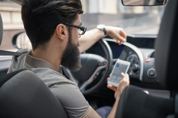 man-using-mobile-phone-while-driving_158595-4198