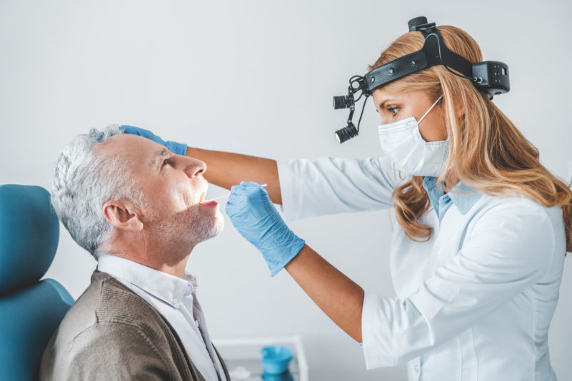 doctor-examines-senior-man-for-sore-throat