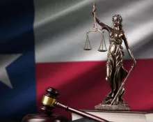 Texas US state flag with statue of lady justice^ constitution and judge hammer on black drapery.