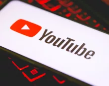 YouTube logo on the screen of a smartphone that is over a keyboard