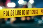 Yellow Tape Showing Text "Police Line Do Not Cross" Restricting a Crime Scene Area At Night. Close Up Aesthetic Shot with Bokeh Effect and Flickering Lights.