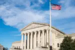 Facade of the United States Suprement Court with American flag in Washington^ DC