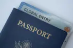 Global Entry card (Trusted traveller) covered of Passport of United states on white background.