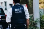 Japanese police squad formation in protective uniform with "Police" logo^ policemen patrol maintain public during political demonstration protest rally in the streets of Tokyo city center^ Japan