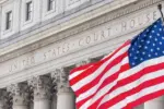 American flag waving in the wind in front of United States Court House in New York