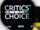 Photo of Critics' Choice Awards homepage on a monitor screen through a magnifying glass.