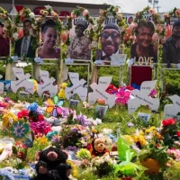 Memorial of flowers^ dove cut-outs and pictures of the African American victims of the mass shooting in Buffalo NY at a Tops supermarket. Buffalo^ New York^ USA- June 11^ 2022