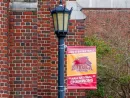 "2022 NAIA Men's Basketball National Champions" banner hangs from lamp post at Louise C. Thomas Hall at Loyola University