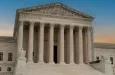 Greek classical architecture of the United States Supreme Court building with sunrise in background.