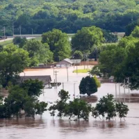 View from 412 Highway to the West of Tulsa Oklahoma as Arkansas river rises and innodates residential area with houses flooded and cars parked in water and a RV tipping over Sand Springs USA 5-25-2019