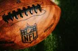 NFL background photo. Ball placed on green grass in beautiful light. NEW YORK^ USA^ SEPTEMBER 11^ 2023