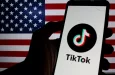Photo illustration of TikTok logo displayed on a smartphone with American Flag in the background.
