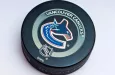 Official Vancouver Canucks game puck on the ice ^product shot