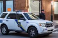 A uniformed Philadelphia Police officer stands beside a police vehicle. PHILADELPHIA^ PA - JANUARY 1^ 2015