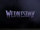 TV on black wall. TV screen playing Netflix series 'Wednesday' trailer