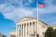 Facade of the United States Suprement Court with American flag in Washington^ DC