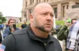 Alex Jones^ flanked by bodyguards^ leaves a rally protesting Covid-19 stay at home orders at the Capitol that was heavily promoted by his Infowars website. Austin^ Tx/USA - Apr. 18^ 2020