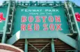 View of the historic architecture of the Fenway Park Stadium showcasing its signs^ brick walls^ statues^ and the famous green color and red letters of the red sox. Boston^ MA^ USA - March 10^ 2023