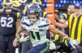 Seattle Seahawks wide receiver Jaxon Smith-Njigba (11) escapes a tackle-attempt by Los Angeles Rams cornerback Emmanuel Forbes Jr. (1) during an NFL football game Nov. 16^ 2025^ in Inglewood^ Calif.