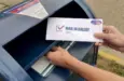 A man puts an absentee mail-in ballot in the mailbox. Circa August^ 2020