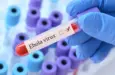 Doctor holding a test blood sample tube with Ebola virus test on the background of medical test tubes with analyzes.