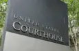 The United States Courthouse sign stands tall amidst a serene backdrop of trees at the US District Court in Seattle^ Washington. Seattle - May 17^ 2019: