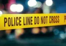 Yellow Tape Showing Text "Police Line Do Not Cross" Restricting a Crime Scene Area At Night. Close Up Aesthetic Shot with Bokeh Effect and Flickering Lights.