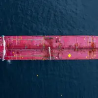 Aerial view crude oil tanker ship at sea^ Red crude oil tanker ship top view^ Logistic and maritime transpoprtation of petroleum^ Modern offshore terminal loading tanker ship.